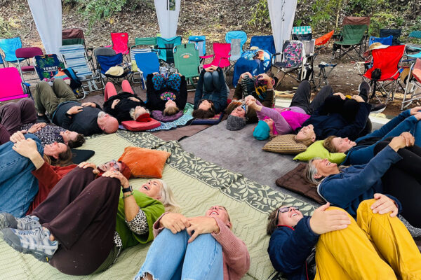 Photo of group lying on backs in a circle radius after participating in a Laughter Yoga session with Carla H Brown