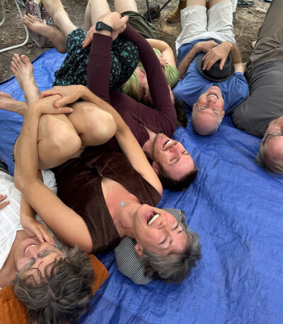 group-of-laughter-yoga-participants-laying-on-their-backs-relaxing-and-laughing-after-a-laughter-yoga-session