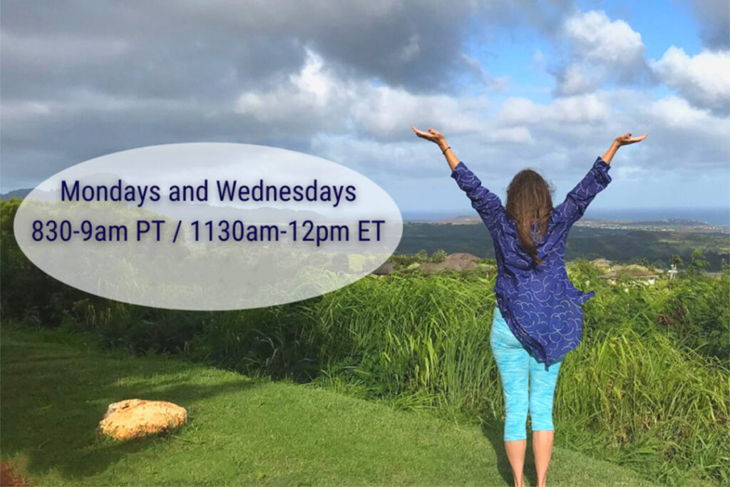 woman-raises-her-arms-in-joyful-pose-as-she-stands-in-open-field-gazing-at-the-horizon